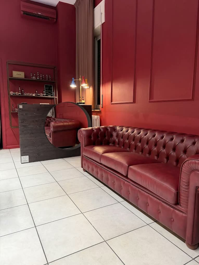 Il divano Chesterfield bordeaux dell'attesa